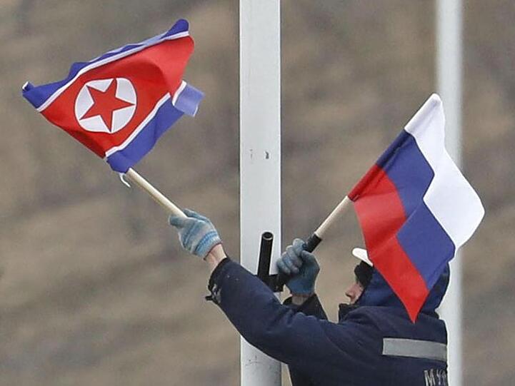 Vorbereitung auf das Treffen: Ein Arbeiter bringt an einer Straße auf der Insel Russki vor Wladiwostok die Flaggen von Russland und Nordkorea an.