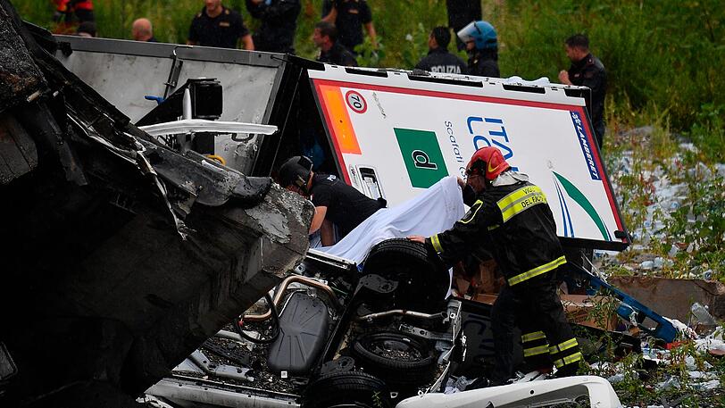 Rettungsarbeiten unter den Trümmern der eingestürzten Morandi Autobahnbrücke.