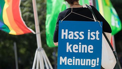 Eine Aktivistin mit einem Plakat mit der Aufschrift "Hass ist keine Meinung". Foto: Frank Rumpenhorst/dpa/Archivbild