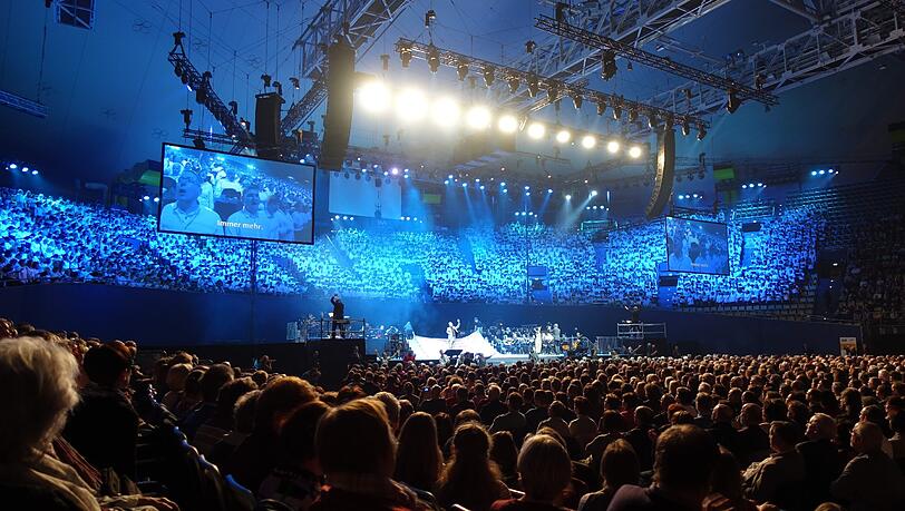 Reformation im musikalischen Großformat: Im Tribünenrund hinter der Bühne: der Chor der 2000. Auf den Podesten die beiden Chordirigenten, in der Mitte die Schauplatz-Bühne und dahinter Orchester und Band. Reformation im musikalischen Großformat: Im Tribünenrund hinter der Bühne: der Chor der 2000. Auf den Podesten die beiden Chordirigenten, in der Mitte die Schauplatz-Bühne und dahinter Orchester und Band.