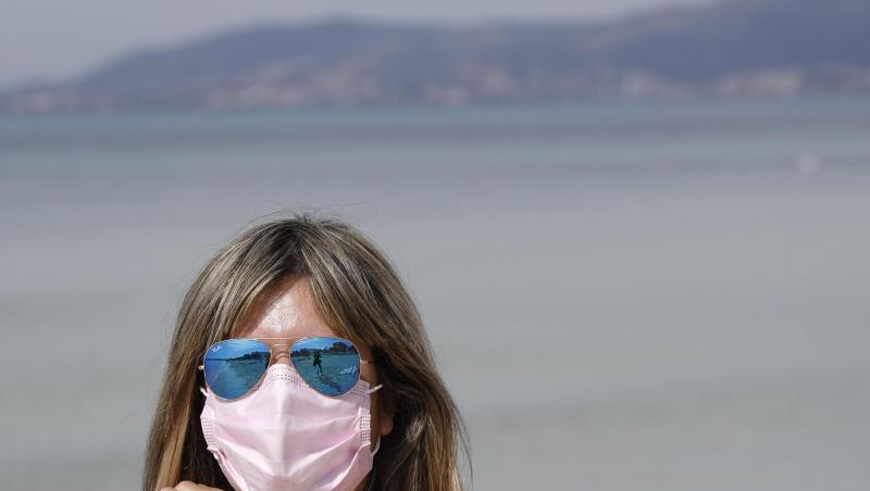 Maske am Strand: Auch 2021 steht der Sommerurlaub - wie hier auf Mallorca - ganz im Zeichen der Pandemie.