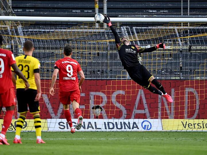 BVB-Keeper Roman Bürki (r) ist beim Schuss von Bayerns Joshua Kimmich machtlos.