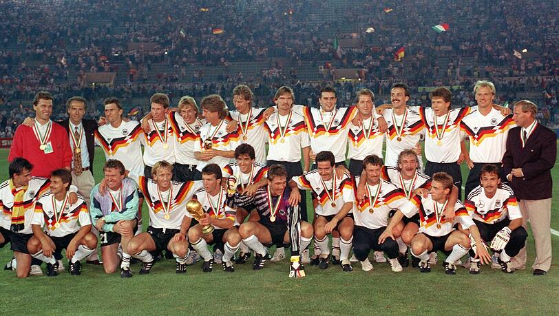 8. Juli 1990 - nach der Siegerehrung bei der WM in Italien und dem 1:0 im Finale gegen Argentinien: Franz Beckenbauer (stehend, Zweiter von links) war damals Teamchef, Lothar Matthäus (unten mit dem der WM-Trophäe) und Thomas Häßler (unten, Zweiter von rechts) tragende Säulen der Mannschaft.
