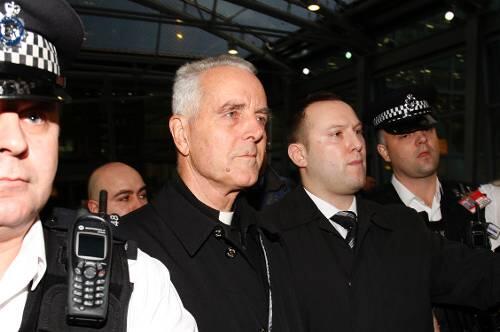Bischof Richard Williamson (Mitte) umringt von Polizisten in London. Gegen ihn ermittelt jetzt die deutsche Justiz.