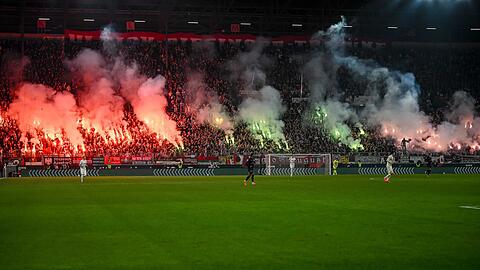 Pyrotechnik brennt beim Spiel FC Augsburg - FSV Mainz 05 im September 2024. (Archivbild)