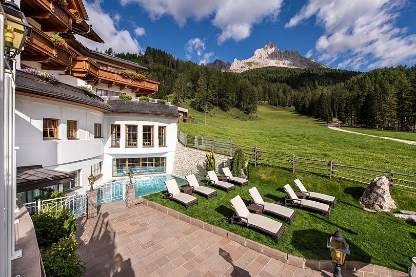Das Genießerhotel Sonnalp mit Wellnessbereich vor dem imposanten Gipfel des Latemar. Das Vier-Sterne-Superior-Hotel liegt auf 1550 Metern im Südtiroler Obereggen – nicht weit von Bozen.