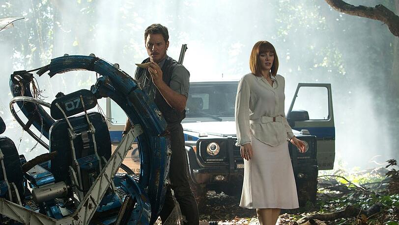 "Jurassic World": Im Wald des Parks finden Owen (Chris Pratt) und Claire (Bryce Dallas Howard) das zerstörte Fahrgerät von Claires Neffen.