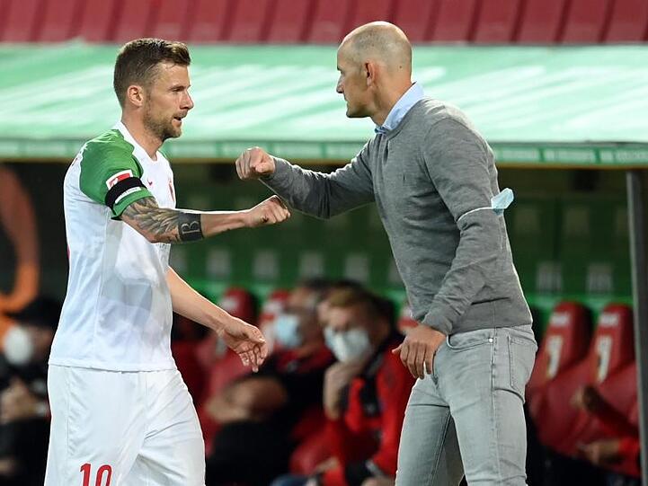 Daniel Baier und sein Trainer Heiko Herrlich stoßen die Ellbogen aneinander bei Baiers Auswechselung. Foto: Matthias Hangst/Getty Images Europe/Pool/dpa/Archivbild