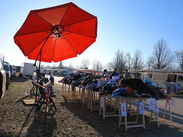 Verkaufsstand mit Sonnenschirm vor dem Käuferansturm.