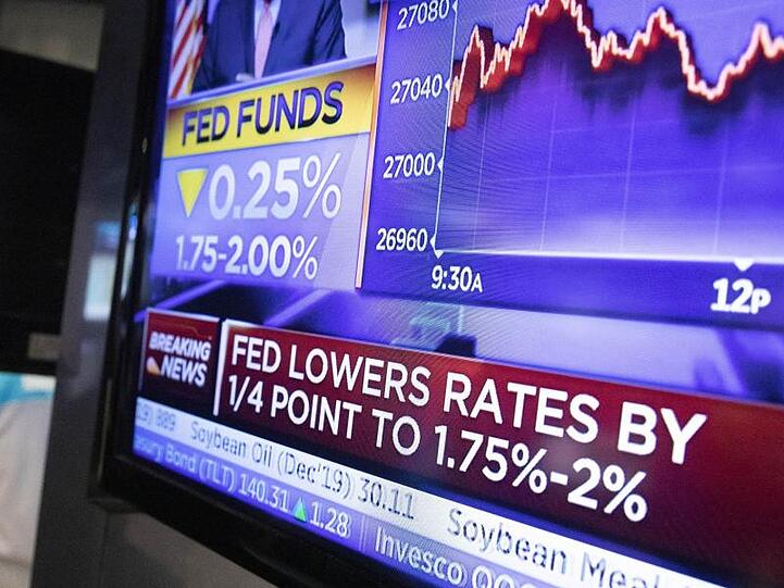 Ein Fernseher an der New Yorker Börse überträgt die Nachricht, dass die US-Notenbank ihre Zinsänderung bekannt gegeben hat.