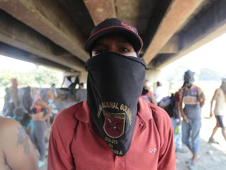 Auch die Regierung hat ihre Anhänger: Ein vermummter Demonstrant, der Maduro unterstützt, steht unter der Grenzbrücke zwischen Kolumbien und Venezuela.