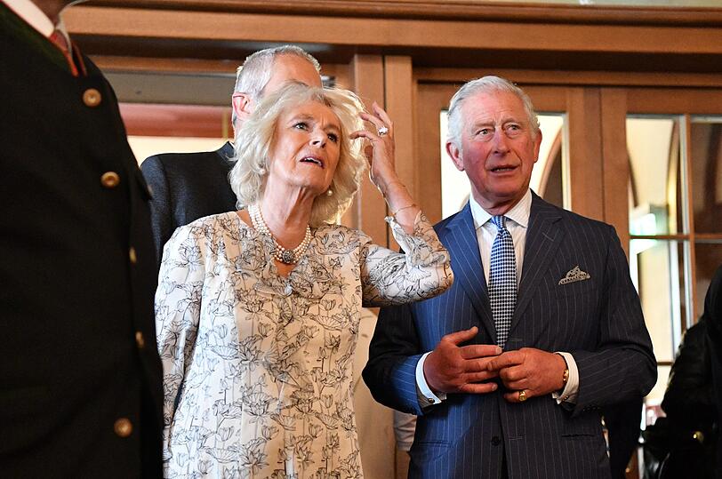 Charles und Camilla tragen sich ins Goldene Buch der Residenz ein.