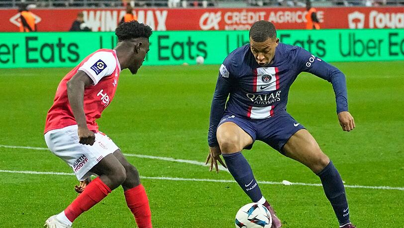 Nathanael Mbuku (l) von Reims versucht Kylian Mbappe von PSG zu stoppen.