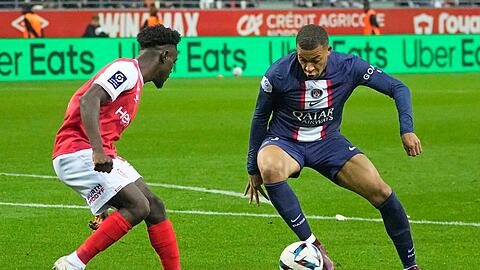 Nathanael Mbuku (l) von Reims versucht Kylian Mbappe von PSG zu stoppen.
