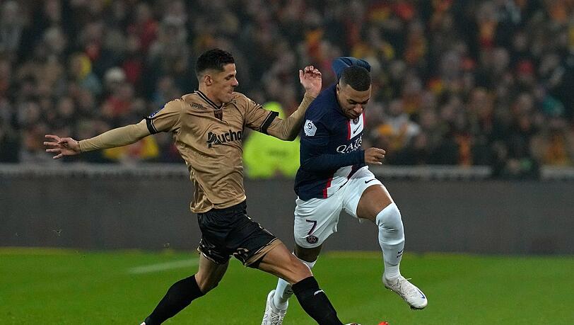 PSG-Stürmer Kylian Mbappé (r) im Zweikampf mit Florian Sotoca von Lens.