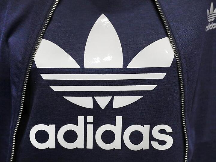 Ein Logo des Sportartikelherstellers Adidas. Foto: Daniel Karmann/dpa/Archivbild