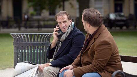 Richard Ratcliffe (Joseph Fiennes, links) bleibt mit seinem Freund Oliver Denton (Sam Troughton) hartn&auml;ckig am Ball, um von London aus mehr &uuml;ber das Schicksal seiner Familie zu erfahren.