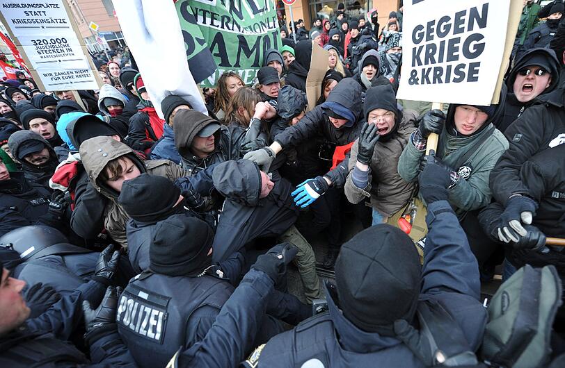 Es kommt zum Gerangel zwischen Demonstranten und der Polizei. Die Polizei greift nach den Demonstranten.