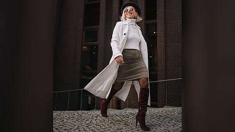 Ein Strickpulli wirkt mit einem Minirock und hohen Stiefeln gleich viel eleganter.