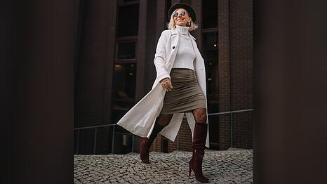 Ein Strickpulli wirkt mit einem Minirock und hohen Stiefeln gleich viel eleganter.