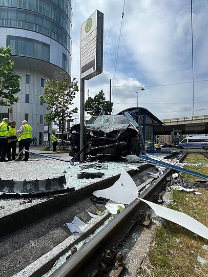 An der Ecke Arnulfstraße/Donnersbergerstraße ist ein Auto in das Wartehäuschen einer Trambahn-Haltestelle hineingefahren.