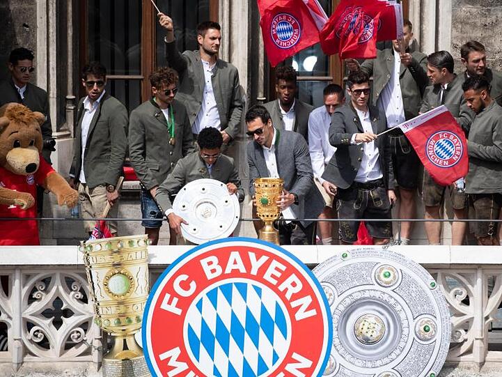 Bayern-Spieler auf dem Balkon des Rathauses am Marienplatz mit der Meisterschale und dem DFB-Pokal.