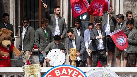Bayern-Spieler auf dem Balkon des Rathauses am Marienplatz mit der Meisterschale und dem DFB-Pokal.