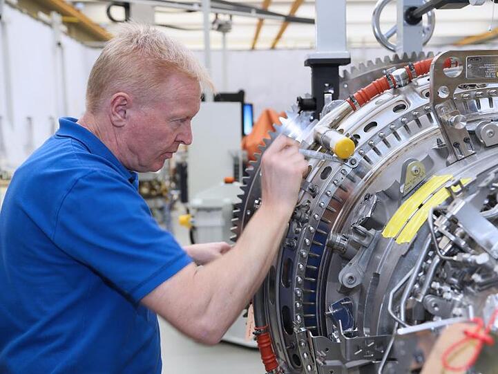 Ein Mitarbeiter arbeitet in einem Werk der MTU Aero Engines AG an einer Flugzeug-Turbine. Foto: -/MTU Aero Engines AG/dpa/Archivbild