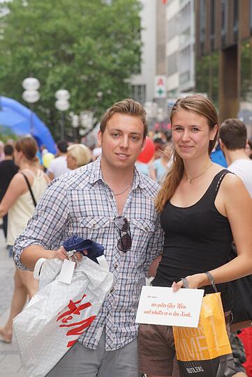 Alex Sanwald (26), Ingenieur, und Isabella Canella (19), Auszubildende: &bdquo;Wir haben ein Schild mit einem lustigen Spruch gekauft als ein spontanes Geschenk und ein cooles T-Shirt. Wir sind wegen des sonnigen Wetters beim Shoppen dabei &ndash; und weil es Spaß macht!&ldquo;
