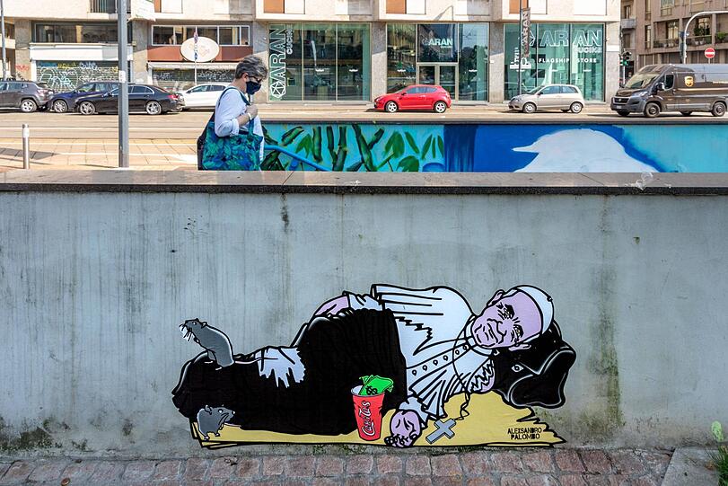 Street-Artist AleXsandro Palombo hat Papst Franziskus als Obdachlosen auf einer Mauer in Mailand verewigt, um auf die neue Armut in Italien aufmerksam zu machen.