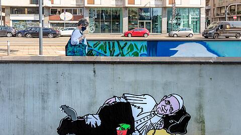 Street-Artist AleXsandro Palombo hat Papst Franziskus als Obdachlosen auf einer Mauer in Mailand verewigt, um auf die neue Armut in Italien aufmerksam zu machen.