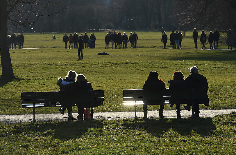 So sah es am ersten Weihnachtsfeiertag im letzten Jahr aus. Menschen sitzen bei Sonnenschein im Englischen Garten.