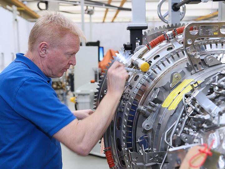Ein Mitarbeiter arbeitet in einem Werk der MTU Aero Engines AG an einer Flugzeug-Turbine.