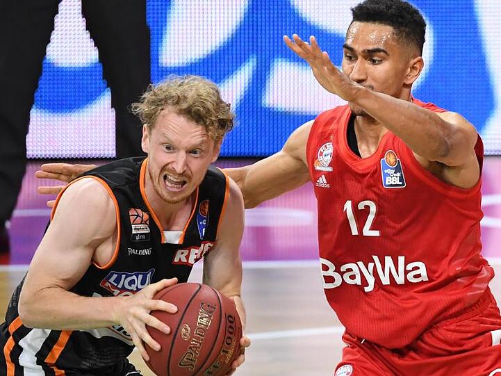 Per Günther von ratiopharm Ulm behauptet sich gegen eine Attacke von Bayerns Maodo Lo (r).