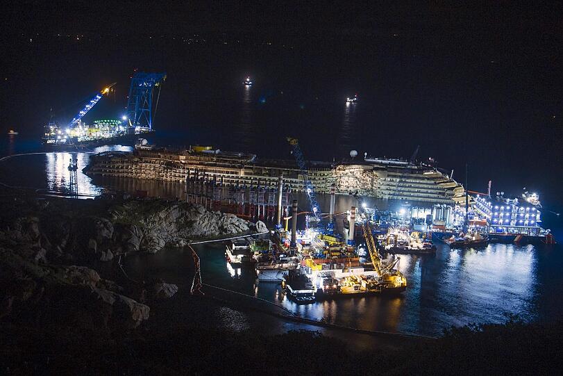 Totalaufnahme: Was für ein Bild! Das Kreuzfahrtschiff steht aufrecht. Es ist kurz vor Sonnenaufgang.