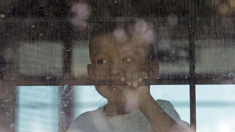 Ein Einwandererkind sieht aus der vergitterten scheibe eines Busses der US-Border Border Patrol. Ein Einwandererkind sieht aus der vergitterten scheibe eines Busses der US-Border Border Patrol.