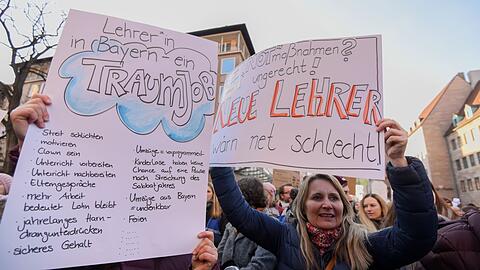 Zahlreiche Menschen nehmen mit Plakaten und Schildern an einer Demonstration teil.