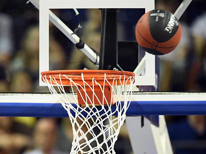 Ein Basketball wird versucht ins Netz zu werfen. Foto: Soeren Stache/dpa/Archivbild