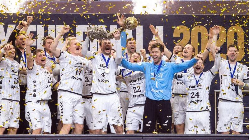 Die Spieler von THW Kiel jubeln im Konfettiregen mit dem Pokal.