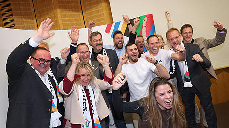 Bayerns Ministerpräsident Markus Söder jubelt im Haus des Sports zusammen mit CSU-OB-Kandidat Clemens Baumgärtner (links), Sportlern, Politikern und Funktionären nach der Bekanntgabe der ersten Hochrechnungen des Bürgerentscheids.
