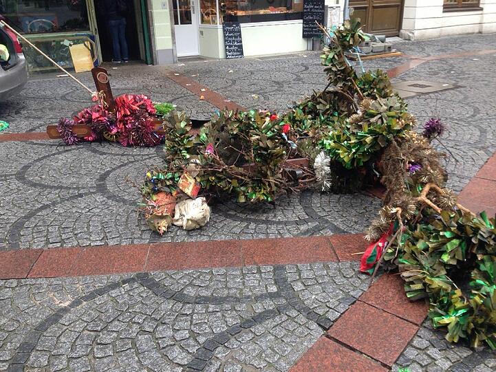 Die Deko ist abgerissen und liegt auf den Pflastersteinen vor der ehemaligen Boazn. Wenn man genauer hinschaut, . . .