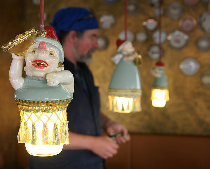 Nikolaus Keller zwischen seinen Milchglas-Kasperlpuppen-Lampen.