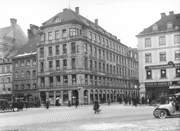 An der Fassade steht es gut lesbar: Landestrachten Wallach. Das Foto stammt aus dem Jahr 1913. Hier, an der Residenzstraße Ecke Perusastraße, hat die Familie Wallach ihr Trachtengeschäft eröffnet, später zog das Geschäft in die Residenzstraße 3.