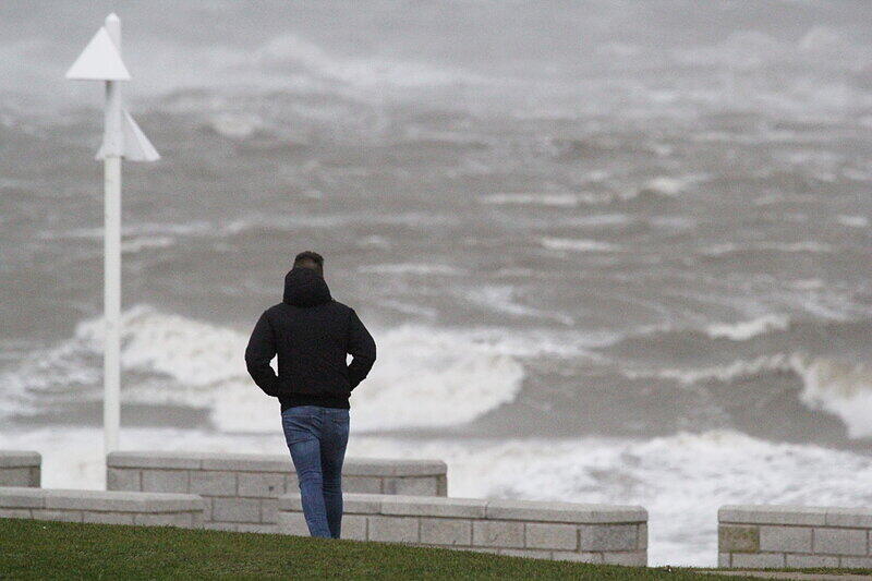 Auch in Niedersachsen peitscht der Sturm die Wellen vorwärts. einInselbesucher blickt auf Norderney über die stürmische See. Sturmtief "Elon" zieht zur Zeit über Norddeutschland hinweg.