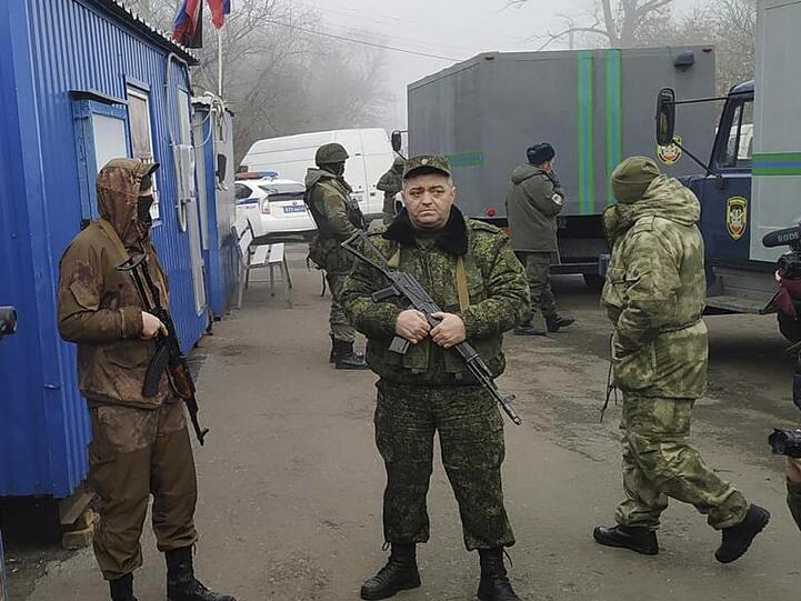 Von Russland unterstützte Separatistensoldaten bewachen in der Stadt Horliwka Fahrzeuge, in denen Ukrainer auf den Gefangenenaustausch warten.