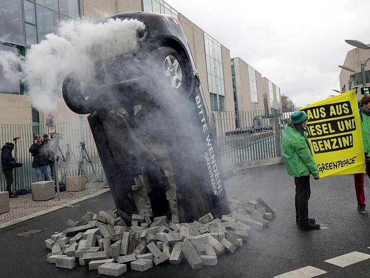 Qualmt und stinkt: Ein von Greenpeace aufgestelltes Auto versperrt die Ausfahrt des Kanzleramtes vor dem Verkehrs-Spitzengespräch.