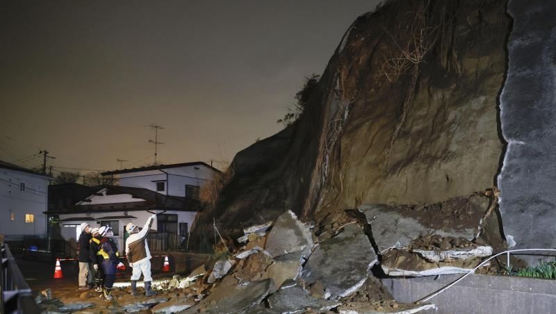 Menschen stehen vor eingestürzten Teilen einer Klippe. Eine Tsunami-Warnung in Folge eines starken Erdbebens im Nordosten Japans ist wieder aufgehoben worden.