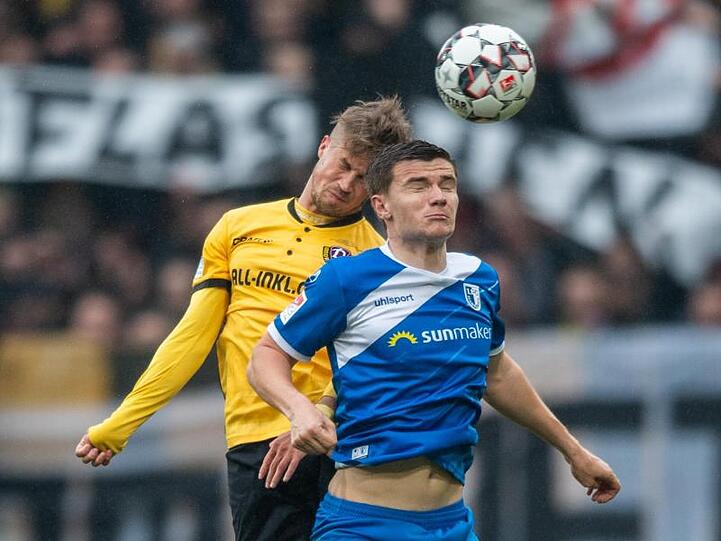 Dynamos Patrick Möschl (l) kämpft gegen den Magdeburger Björn Rother um den Ball.