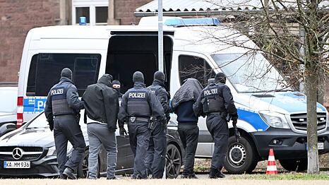 Zwei mutma&szlig;liche Hamas-Mitglieder werden von Polizisten bei einem Hubschrauberlandeplatz von einem Hubschrauber zu einem Auto gef&uuml;hrt. (Archivbild)