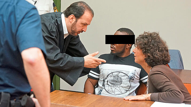 Vor dem Prozess: der Angeklagte zwischen Anwalt und Dolmetscherin.